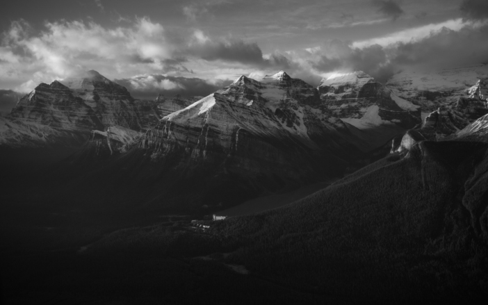 A mix of sun and cloud over the snow-capped Rocky Mountains in Lake Louise.