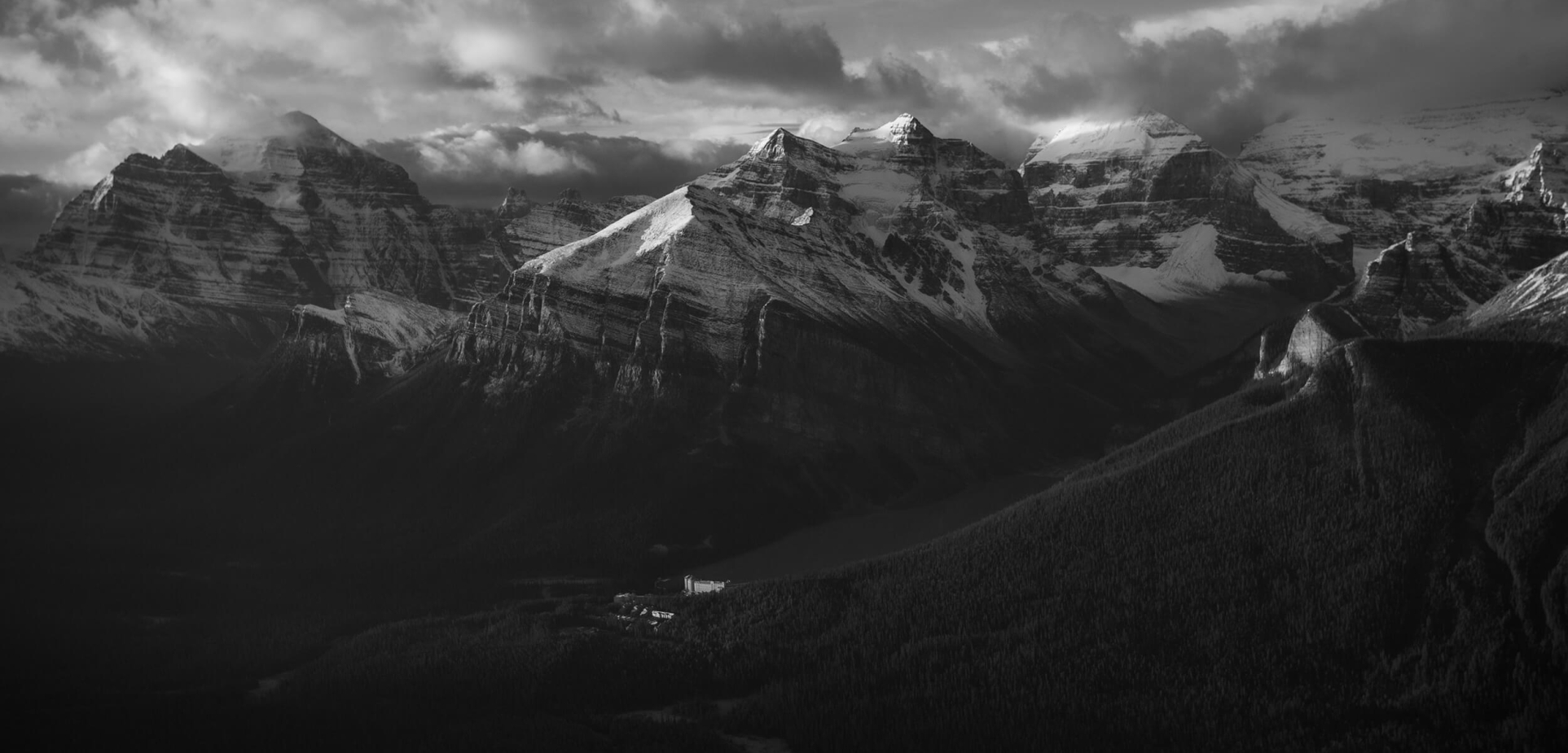 A mix of sun and cloud over the snow-capped Rocky Mountains in Lake Louise.