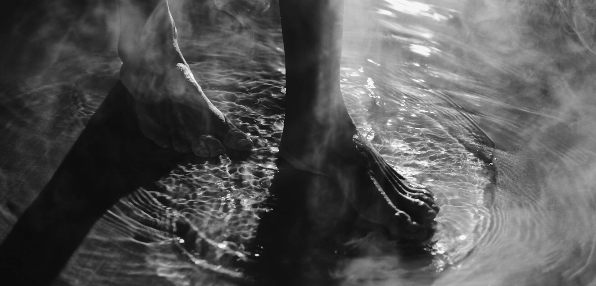 Bare feet walking through a steamy wet surface.