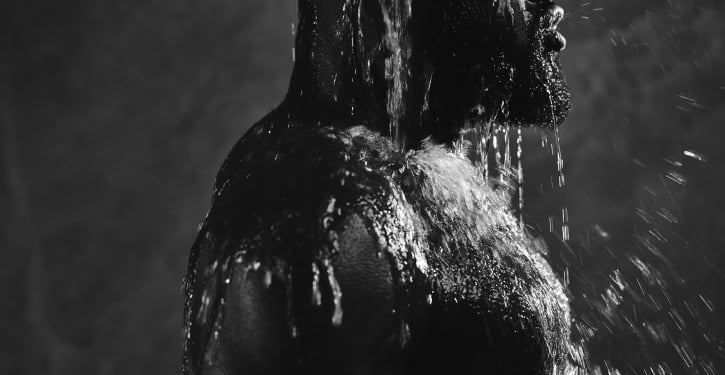 Man enjoying refreshing cold water bucket shower